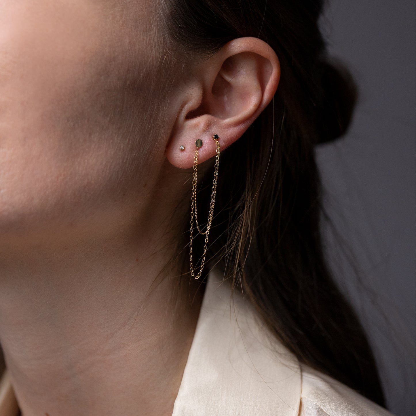 18 ct yellow gold double earring with black diamond and oval stud on model