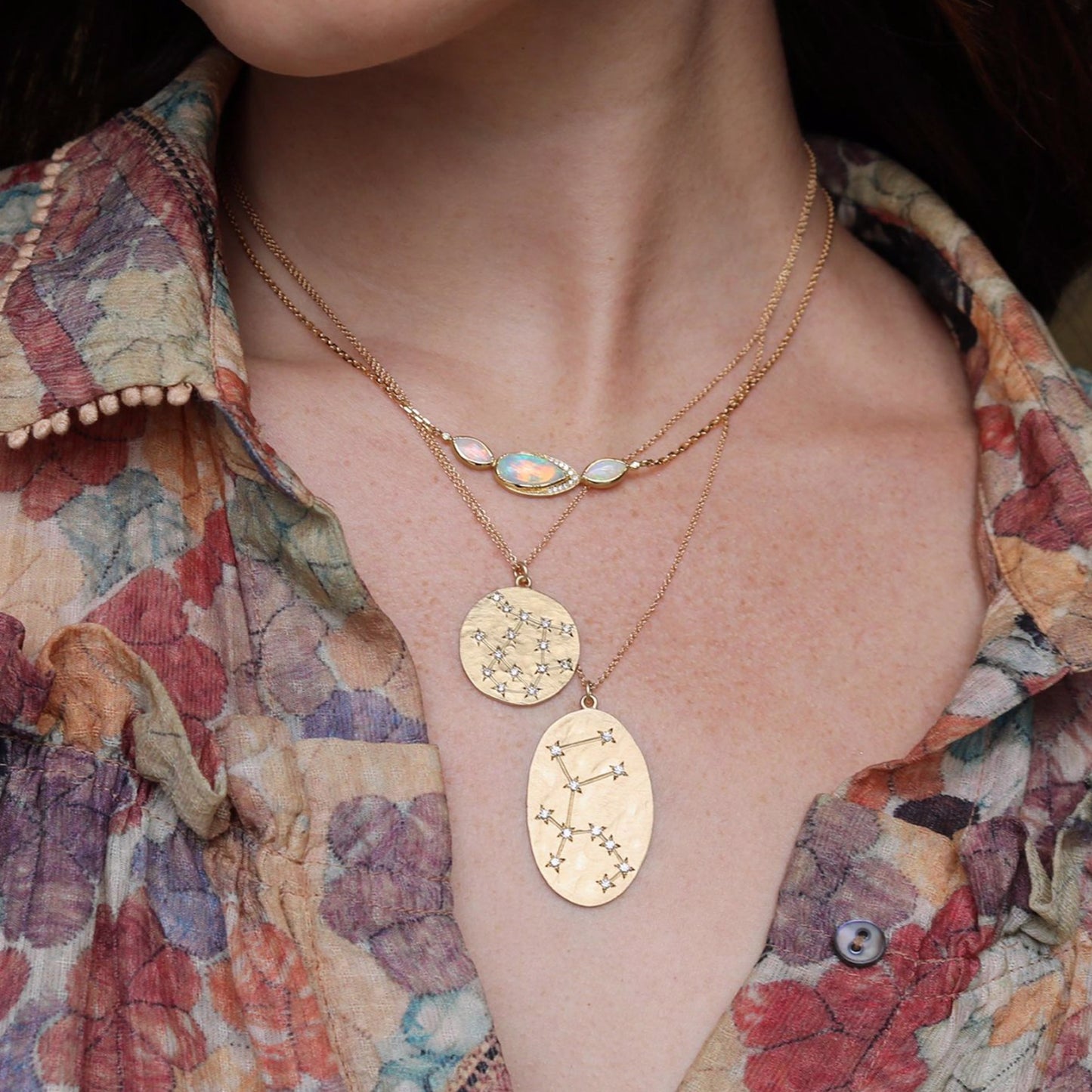 Brooke Gregson 14k brushed gold Aquarius Astrology pendant chain necklace set with 11 diamonds layered with another zodiac pendant and opal necklace.