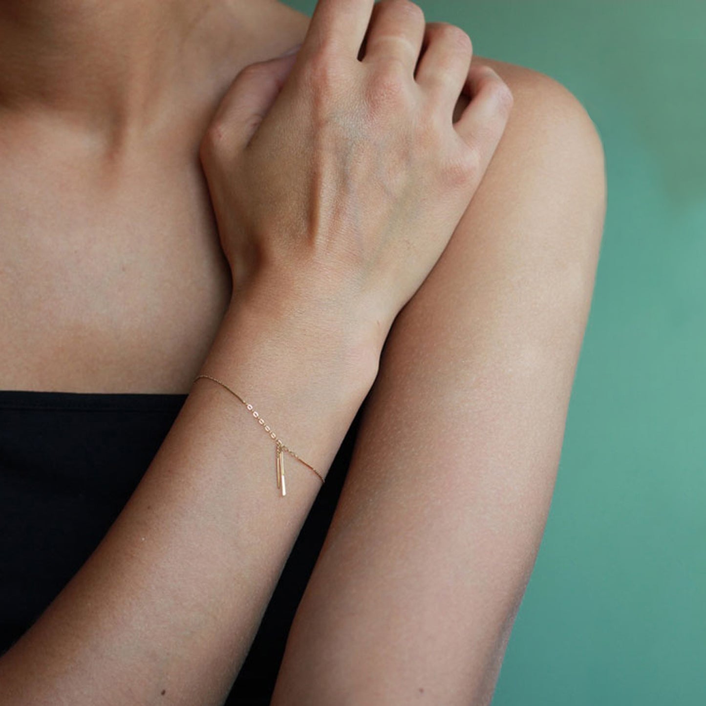 18ct gold fine chain bracelet with hanging bars on model
