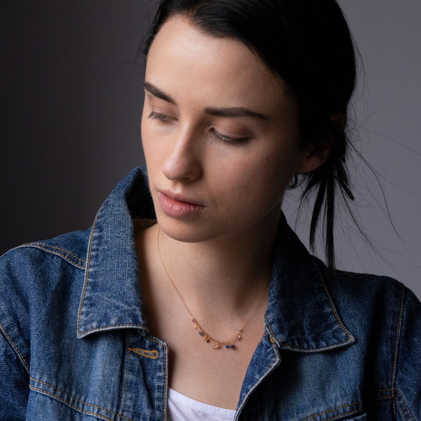 18ct yellow gold fine chain necklace with layered chain section and mixed precious stones on model