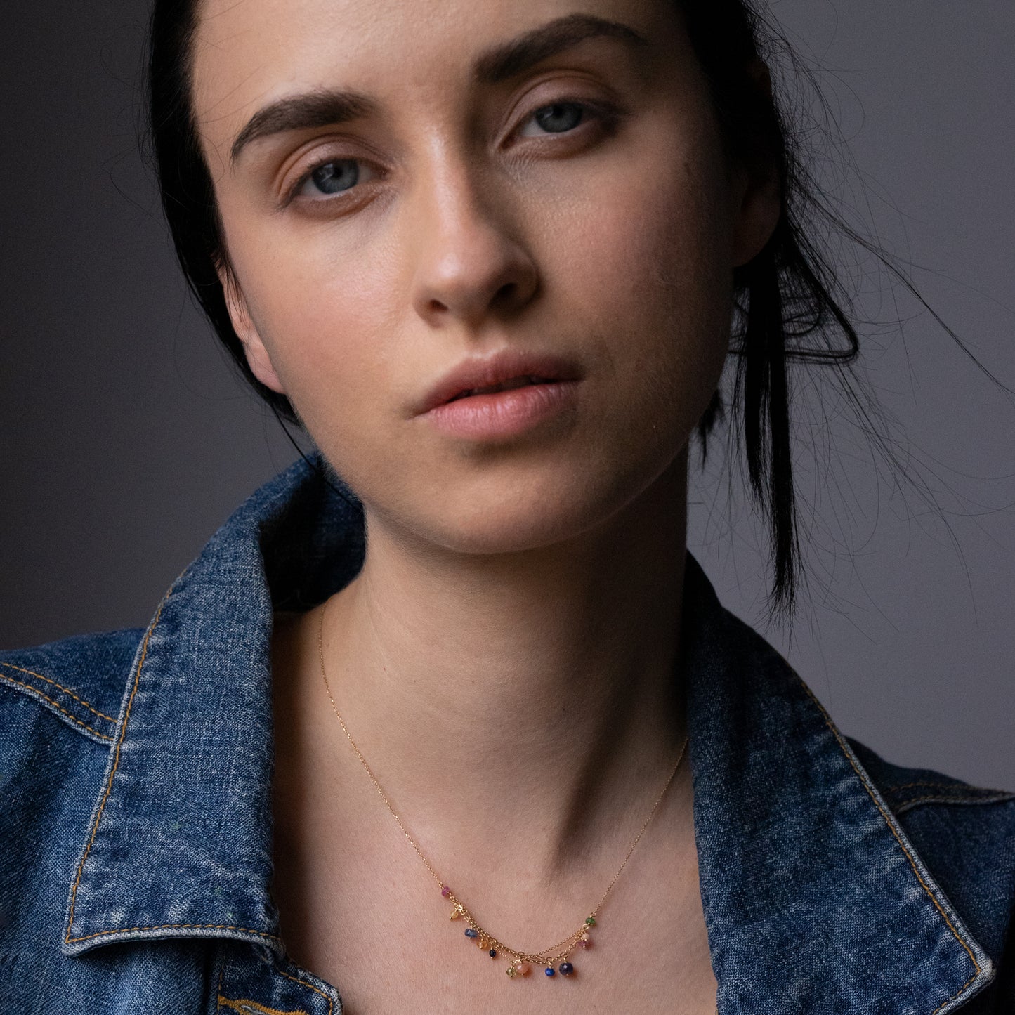 18ct yellow gold fine chain necklace with layered chain section and mixed precious stones on model