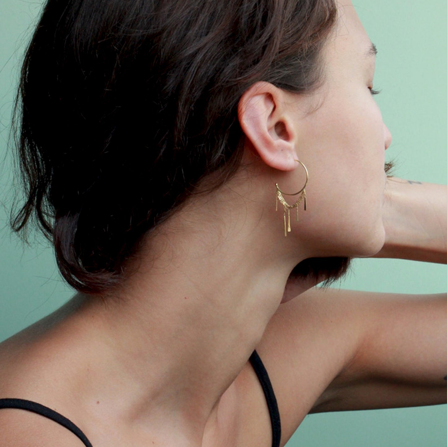 18ct gold medium hoop earring with a looped layered chain and hanging 5 bars on model