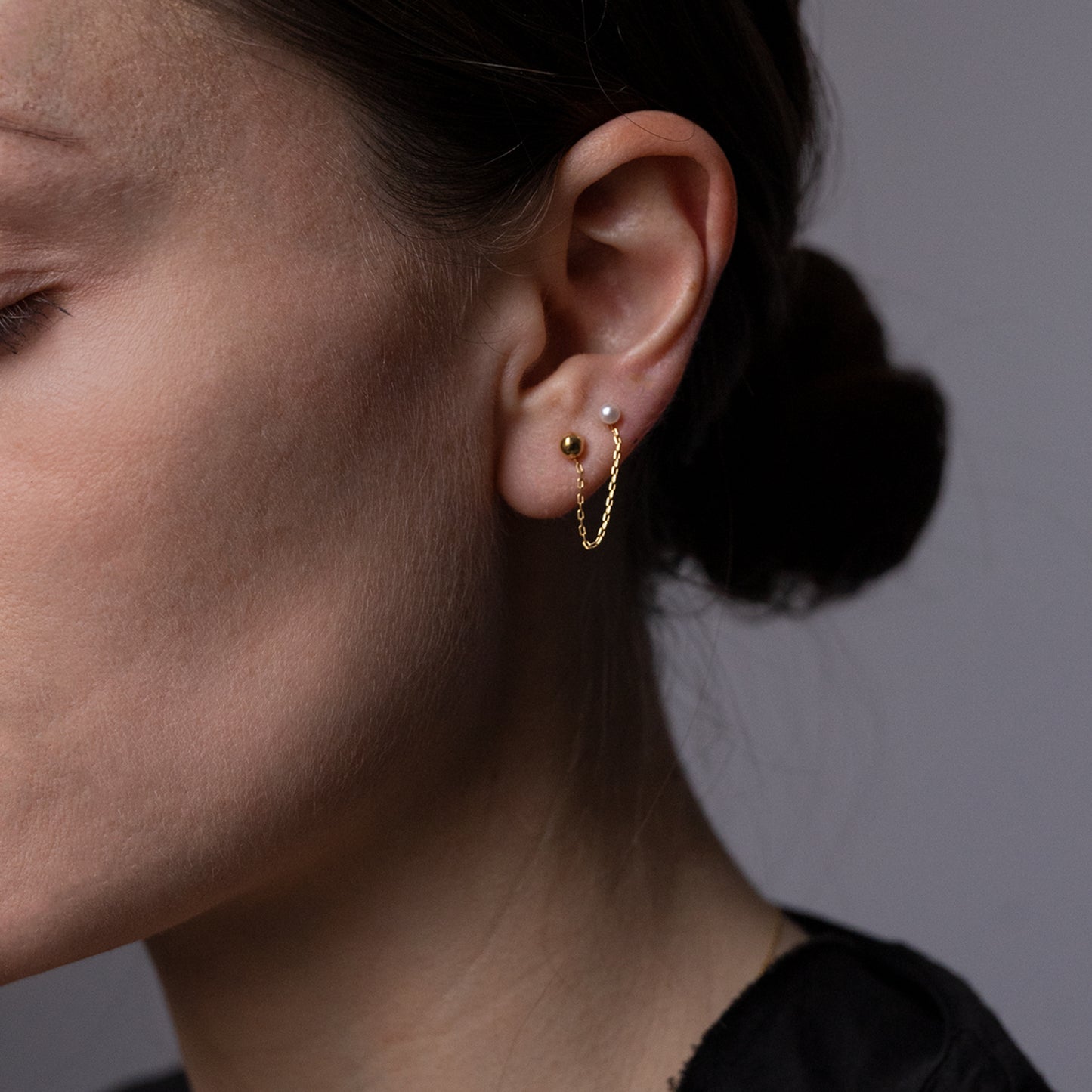Golden Ball and Pearl Double Stud 18ct yellow gold double stud with pearl and golden ball on model