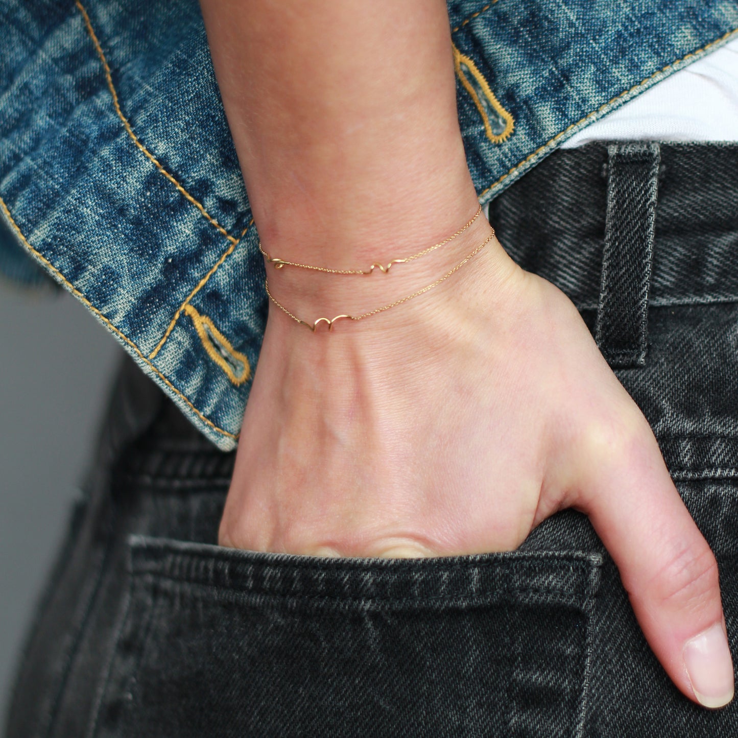 18ct yellow gold fine chain double strand bracelet with 3 inserted Doodles on model