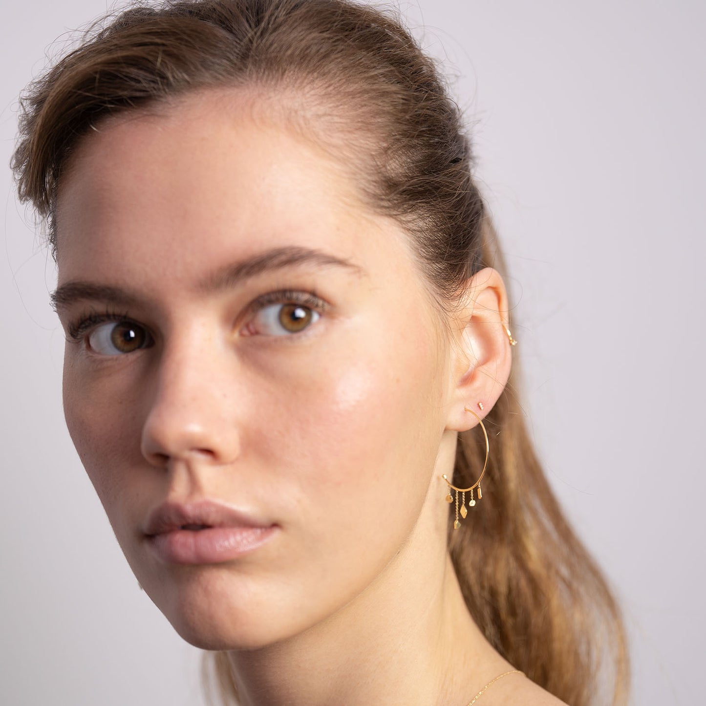 18ct Gold baby hoop with mixed gold shapes on model