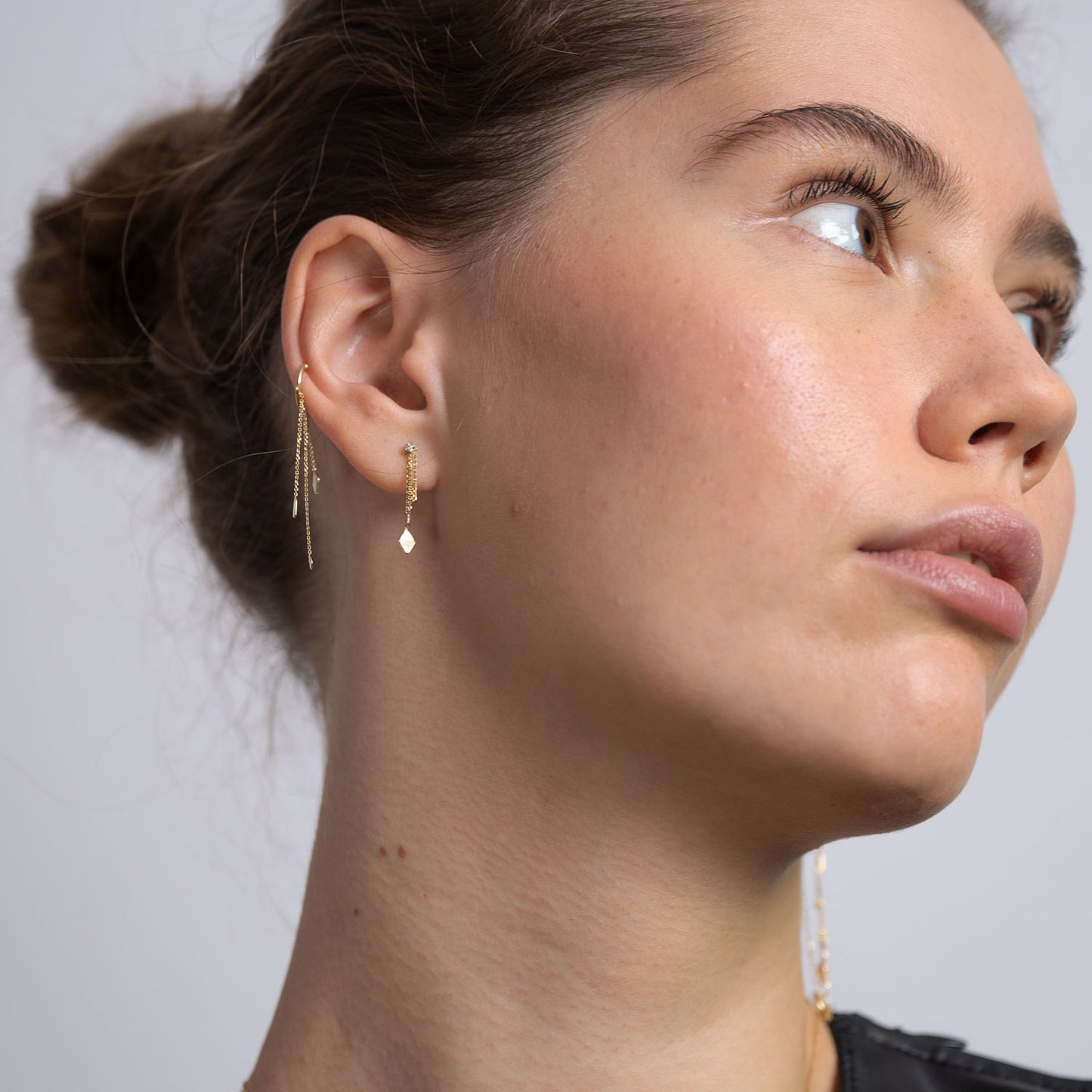 18ct Gold cuff with three hanging chains and mixed gold shapes on ends on model