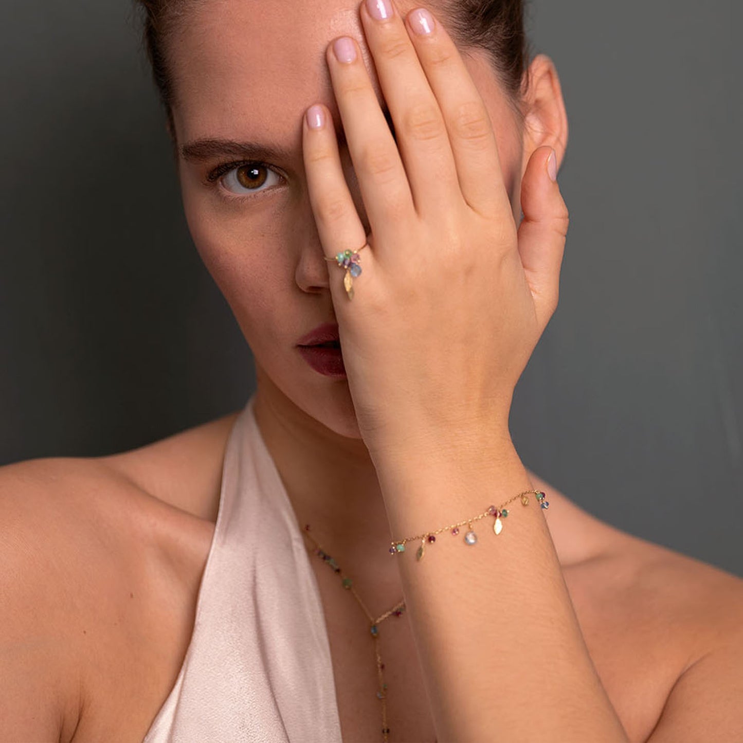18ct Gold chain bracelet with mixed stones and three hanging gold leaves worn by model