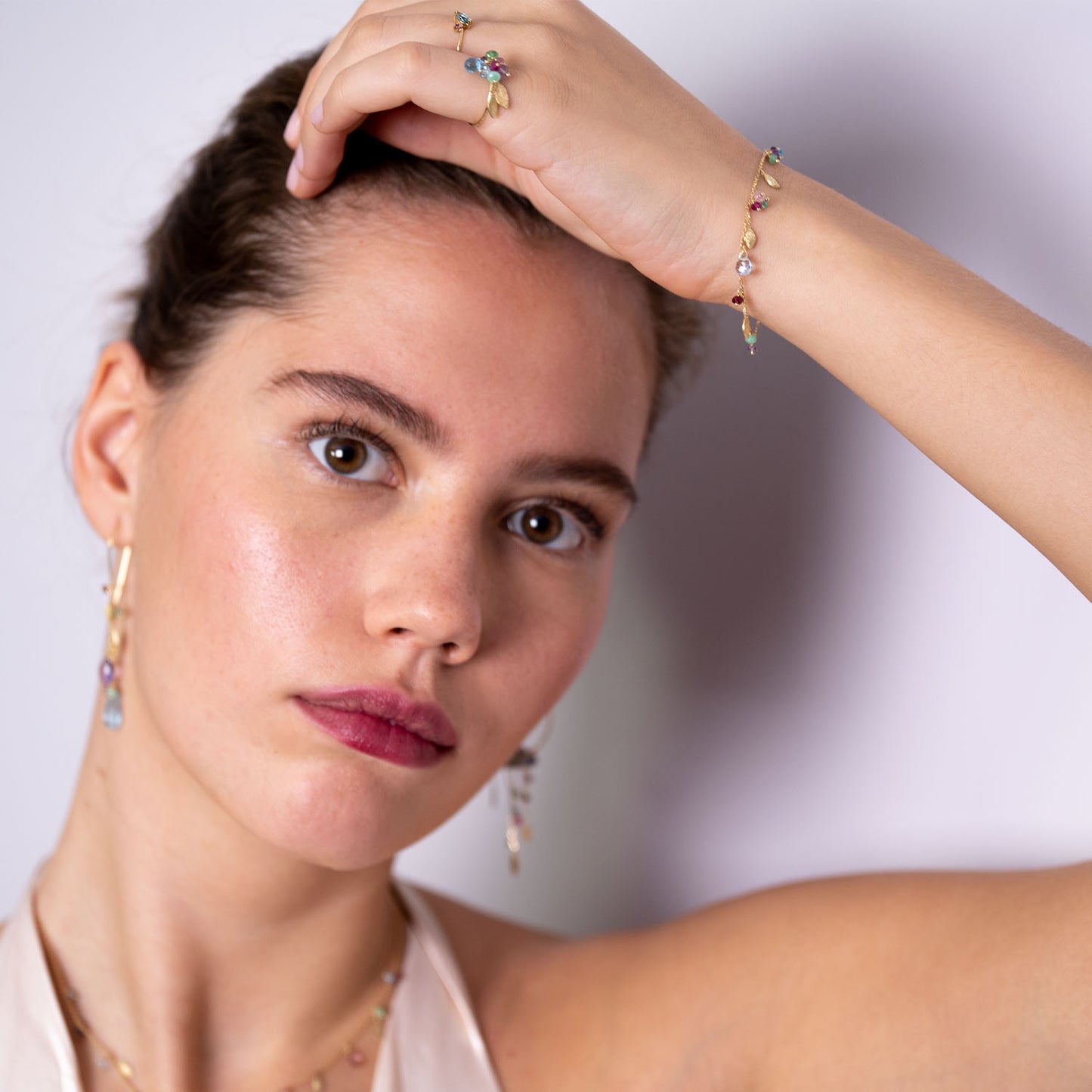 18ct Gold chain bracelet with mixed stones and three hanging gold leaves worn by model