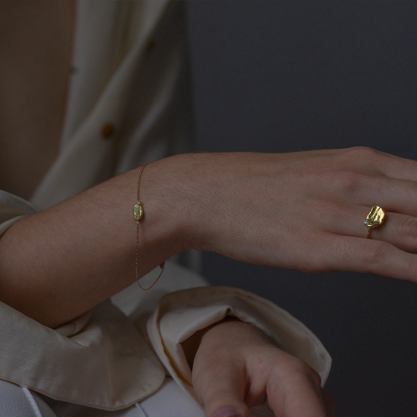 Sweet Pea Moonscape recycled 18ct yellow gold nugget chain bracelet set with white diamond on a women wrist, the matching diamond nugget ring can also be seen on her finger. 