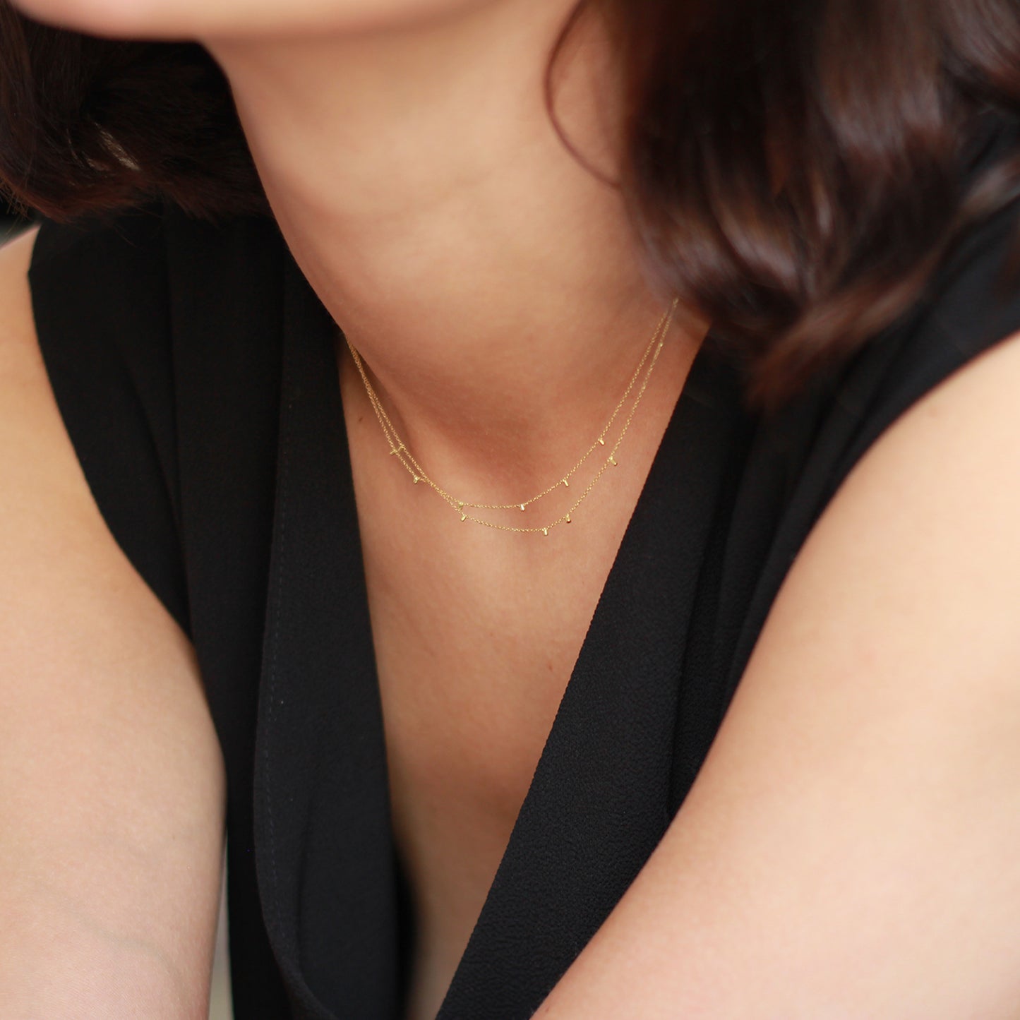 model wearing This cute 18 ct yellow double strand necklace is made of fine chain sprinkled with a shimmering of gold embellishments and is part of our Gold Dust Collection.