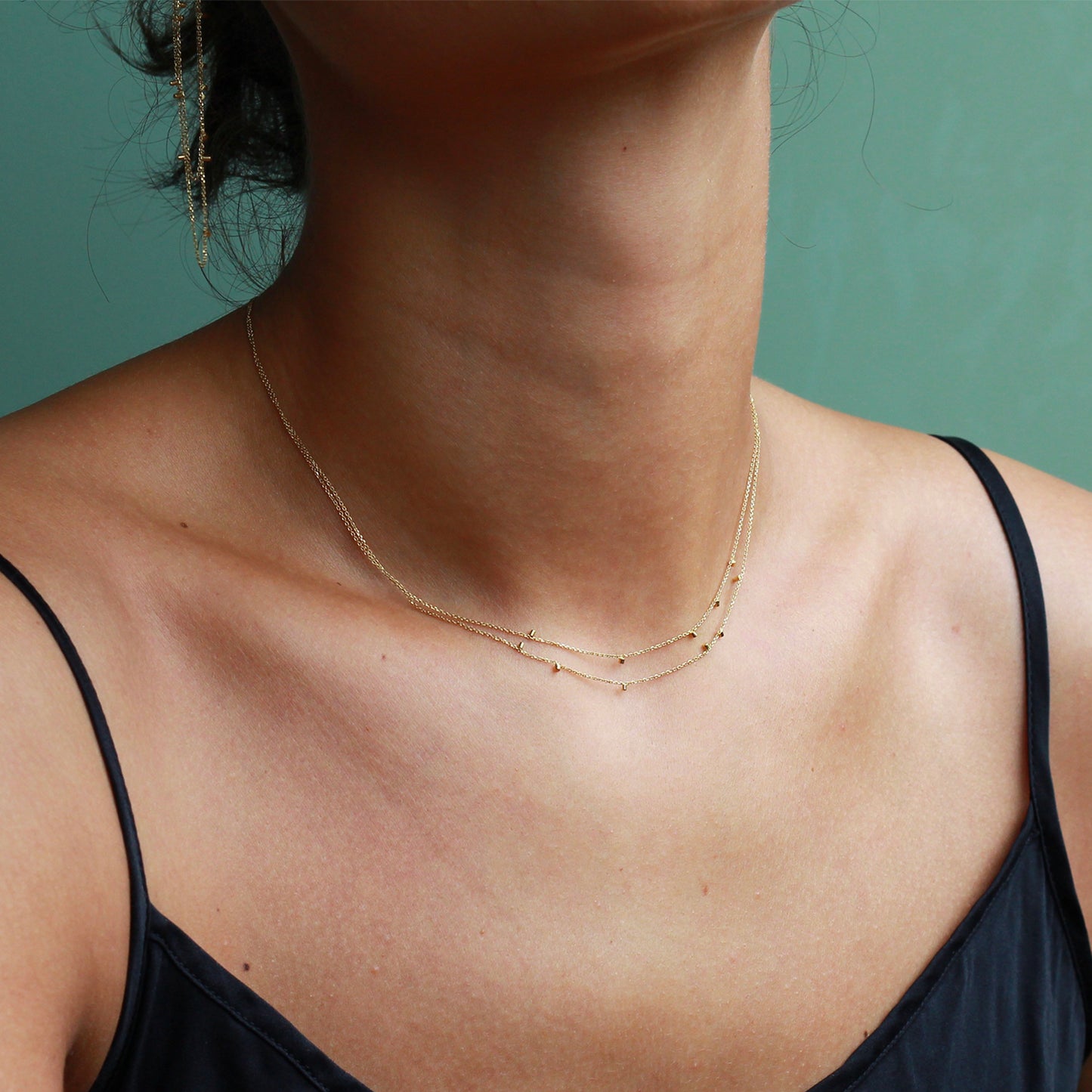 model wearing This cute 18 ct yellow double strand necklace is made of fine chain sprinkled with a shimmering of gold embellishments and is part of our Gold Dust Collection.