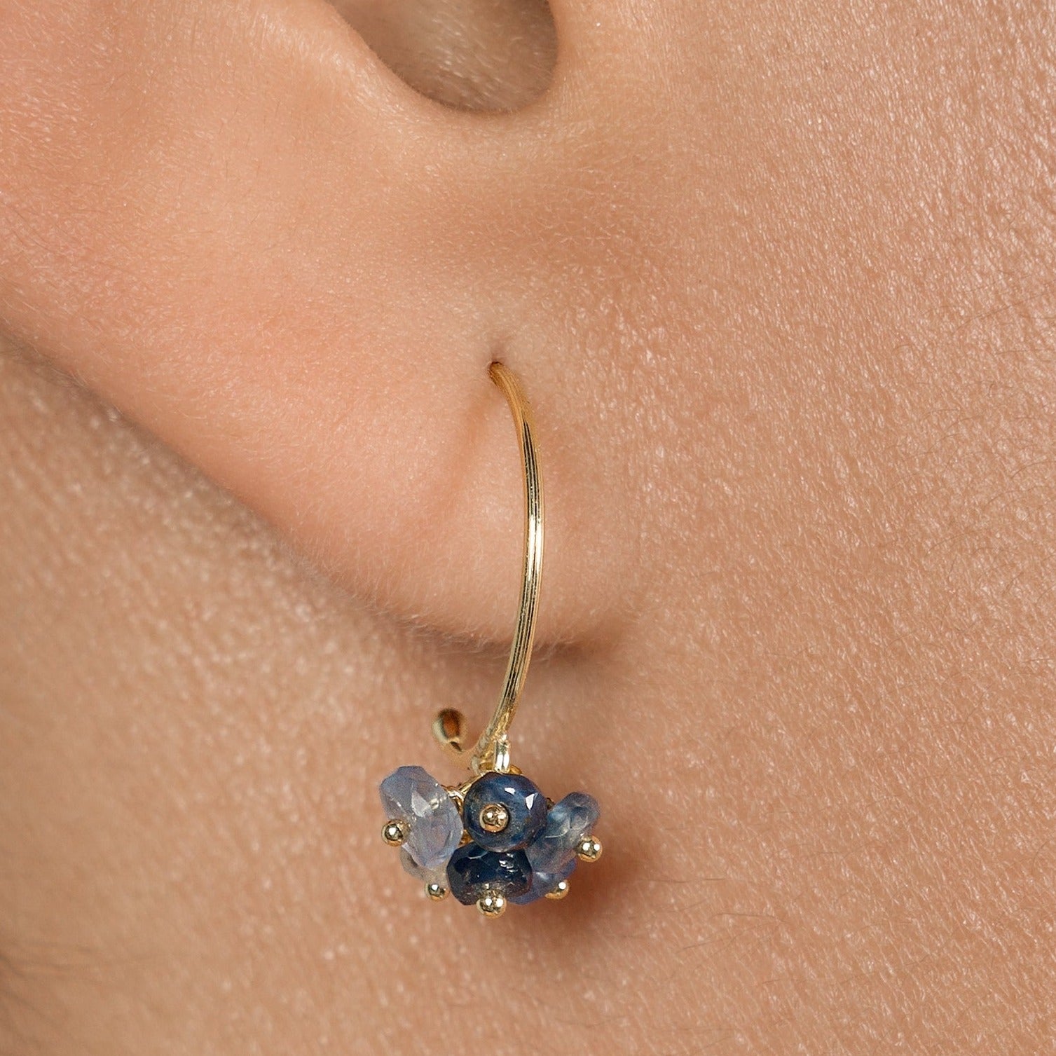 Sweet Pea Pogo Punk 18ct yellow gold small hoops with cluster of sapphire beads in varying shades on model.