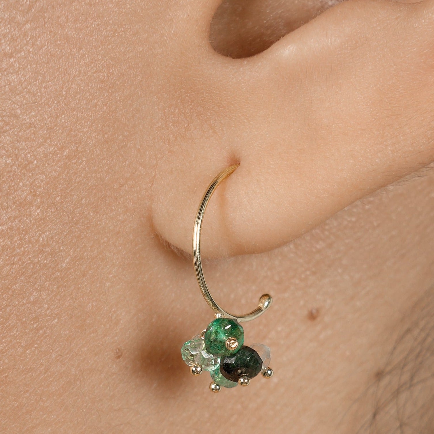Sweet Peas Pogo Punk 18ct yellow gold small hoops with cluster of emerald beads in varying shades on model.