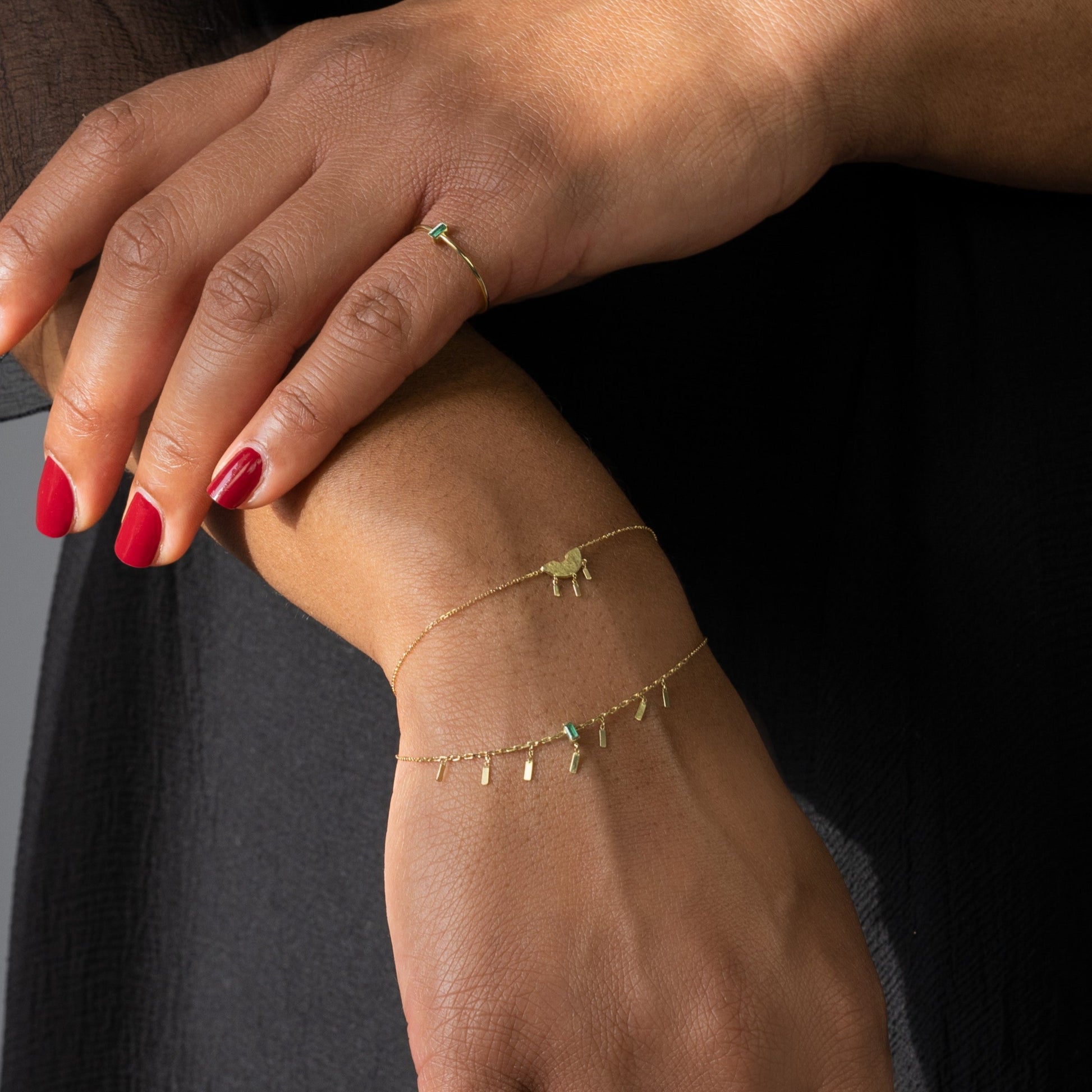 Enchanting 18ct gold curved bar bracelet with 3 charms on model. 