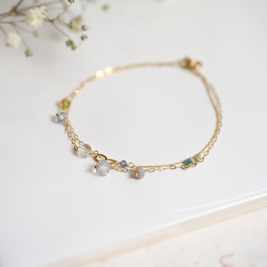 18ct yellow gold double strand bracelet from our Busby Babes collection has a mix of precious bead including iolite, grey topaz, green corrundum, yellow tourmaline and smokey amethyst.