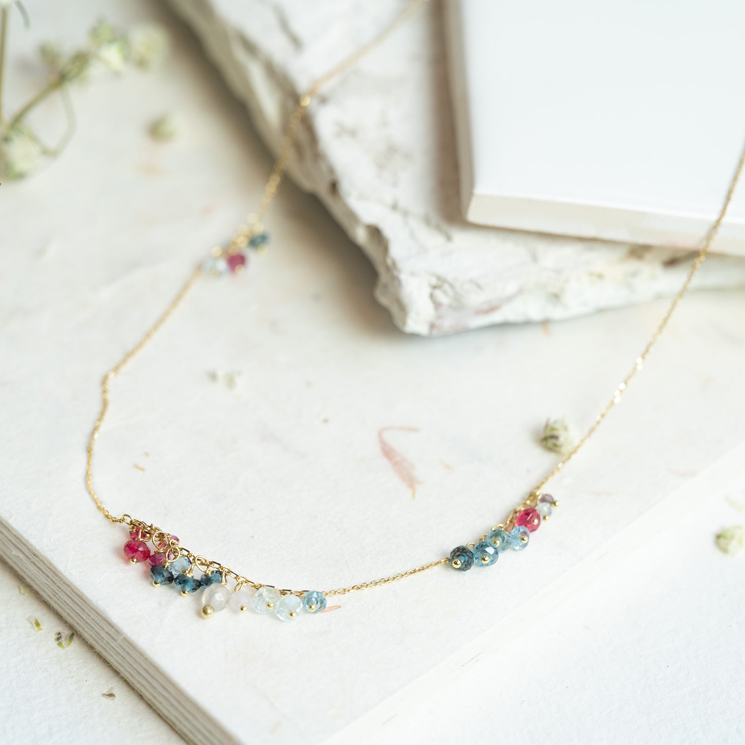 18ct yellow gold fine chain necklace from our 'Oh I Do Like to be Beside the Seaside' collection has clusters of Red Spinel, Pink Tourmaline and mixed Blue Topaz beads.