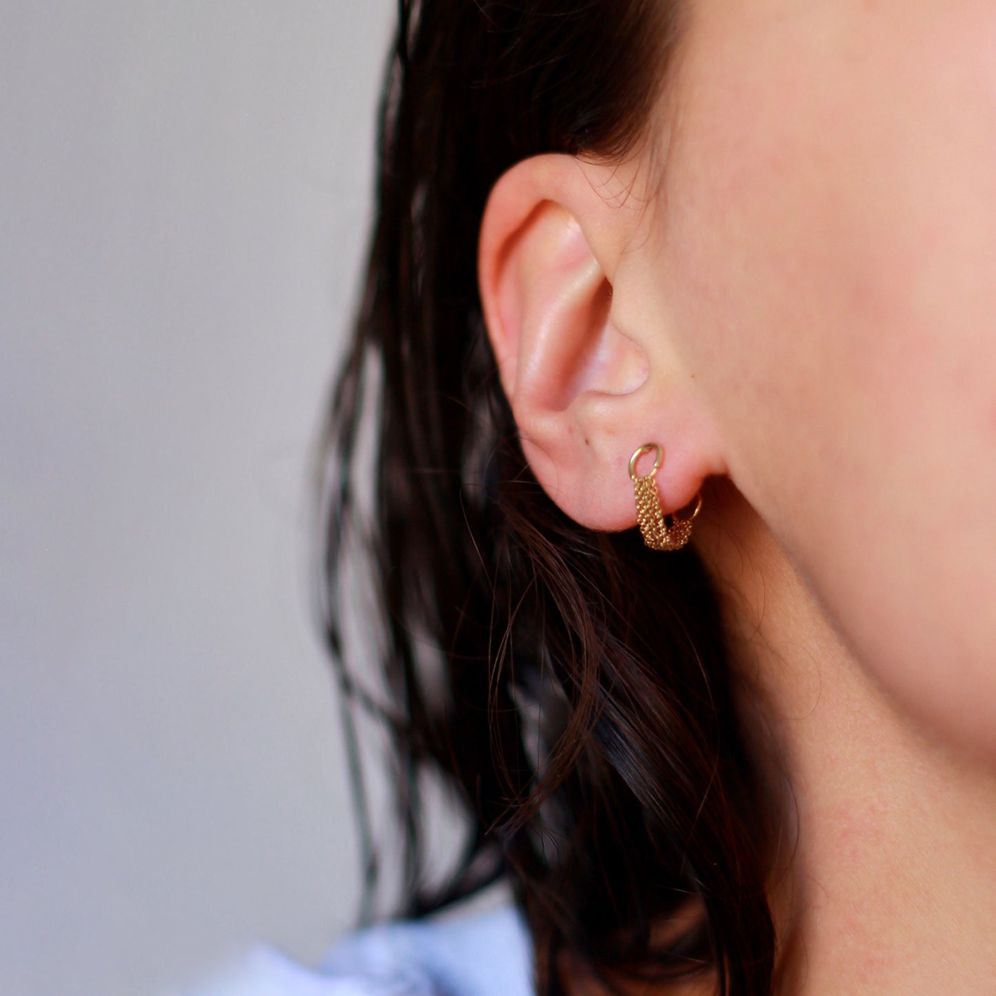 18 CT YELLOW GOLD STUDS WITH LOOPED CHAIN TO BACK on model