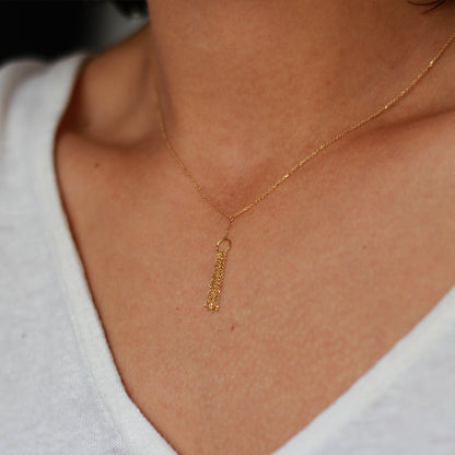18ct yellow gold Take A Bow necklace with a single circle layered with glistening hanging chains. on model