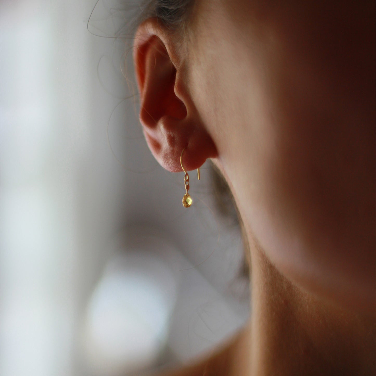 18ct yellow gold, yellow briolette drop hook earring on model. 20% of sale going to Breast Cancer Support 