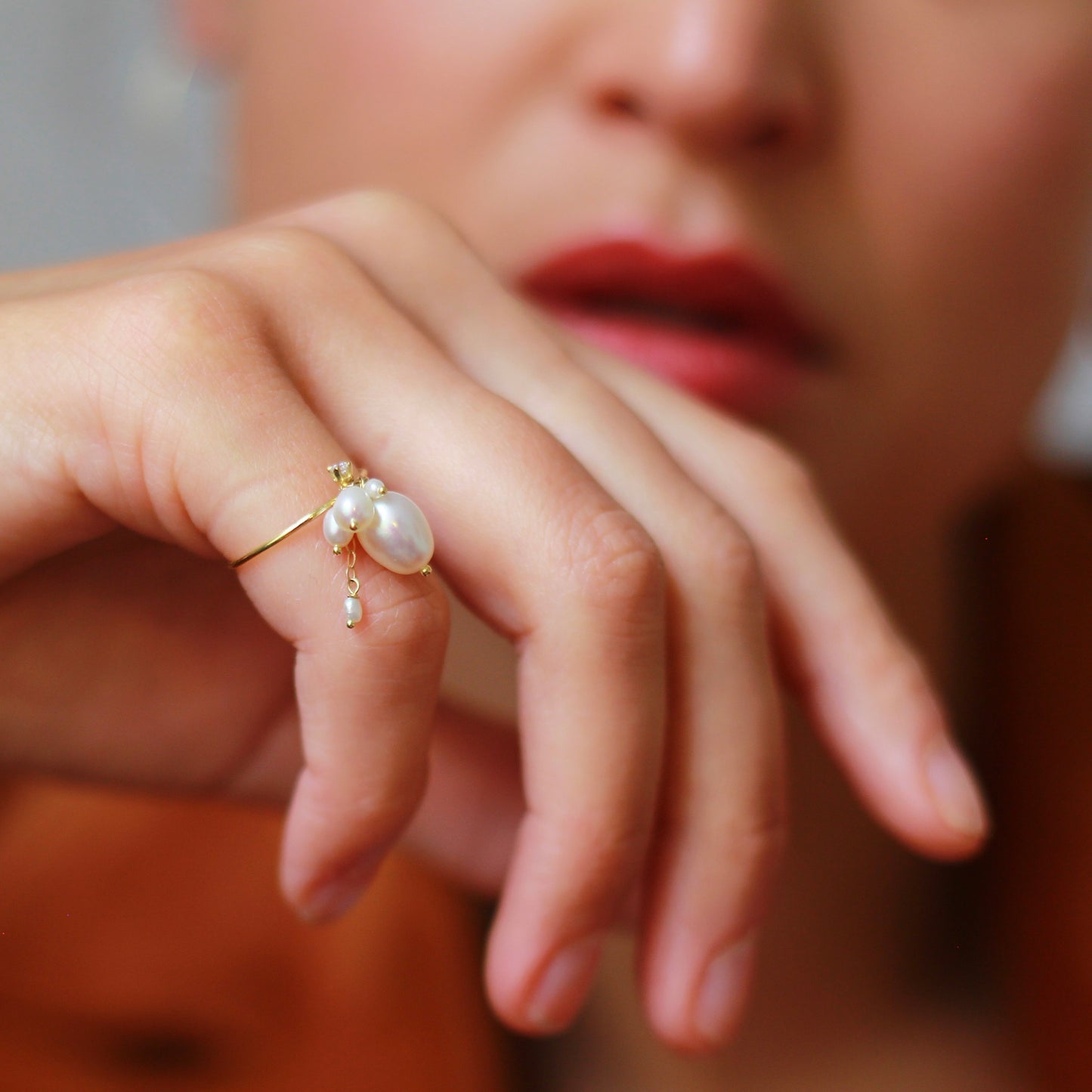 18ct yellow gold ring from our Snowdrop Pearl collection has white oval shaped fresh water pearls, mixed fine chain hanging detail along with a diamond set charm on model