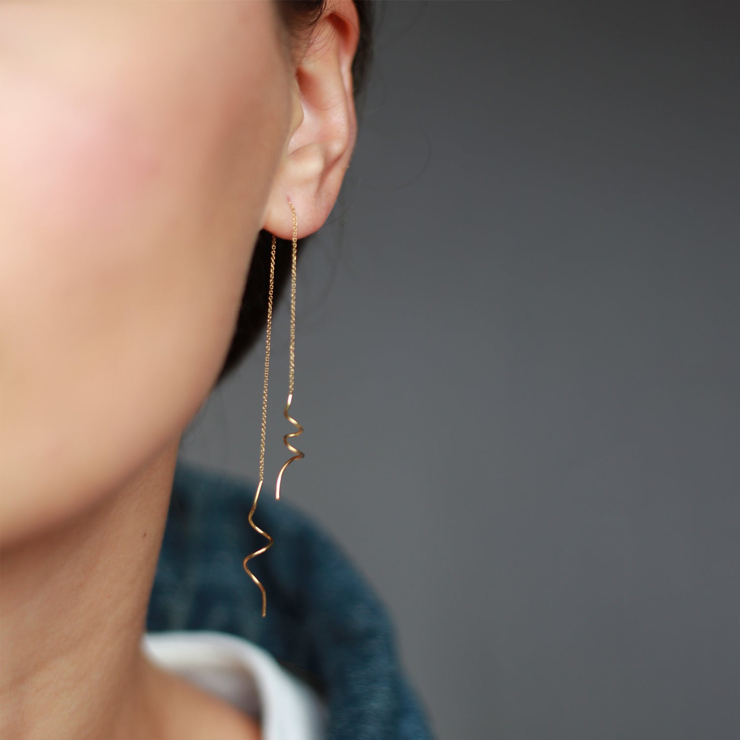 18ct yellow gold thread through earrings with hanging doodles on both ends on mode