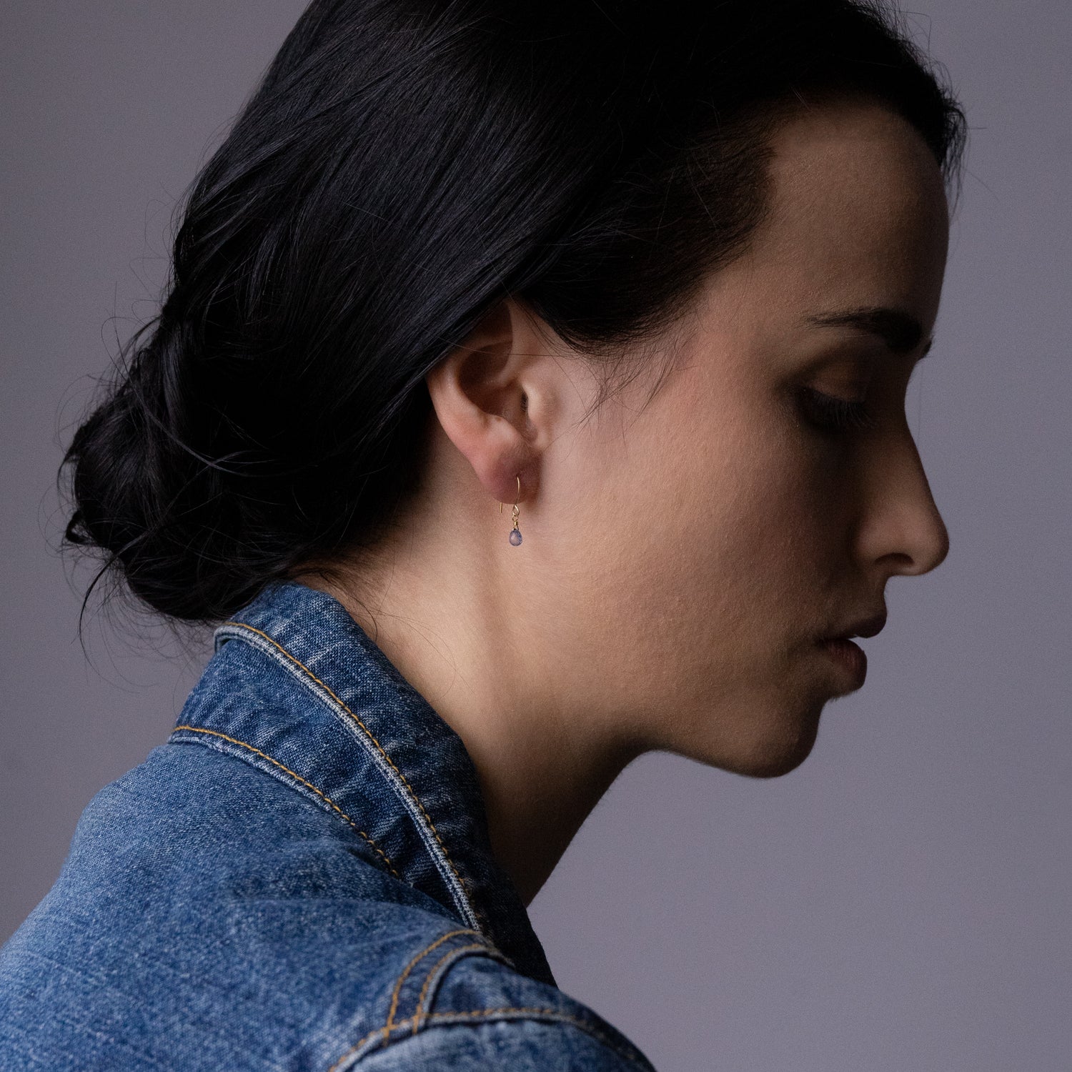 18ct yellow gold fine hook earrings with cornflour blue Sapphire drop on model