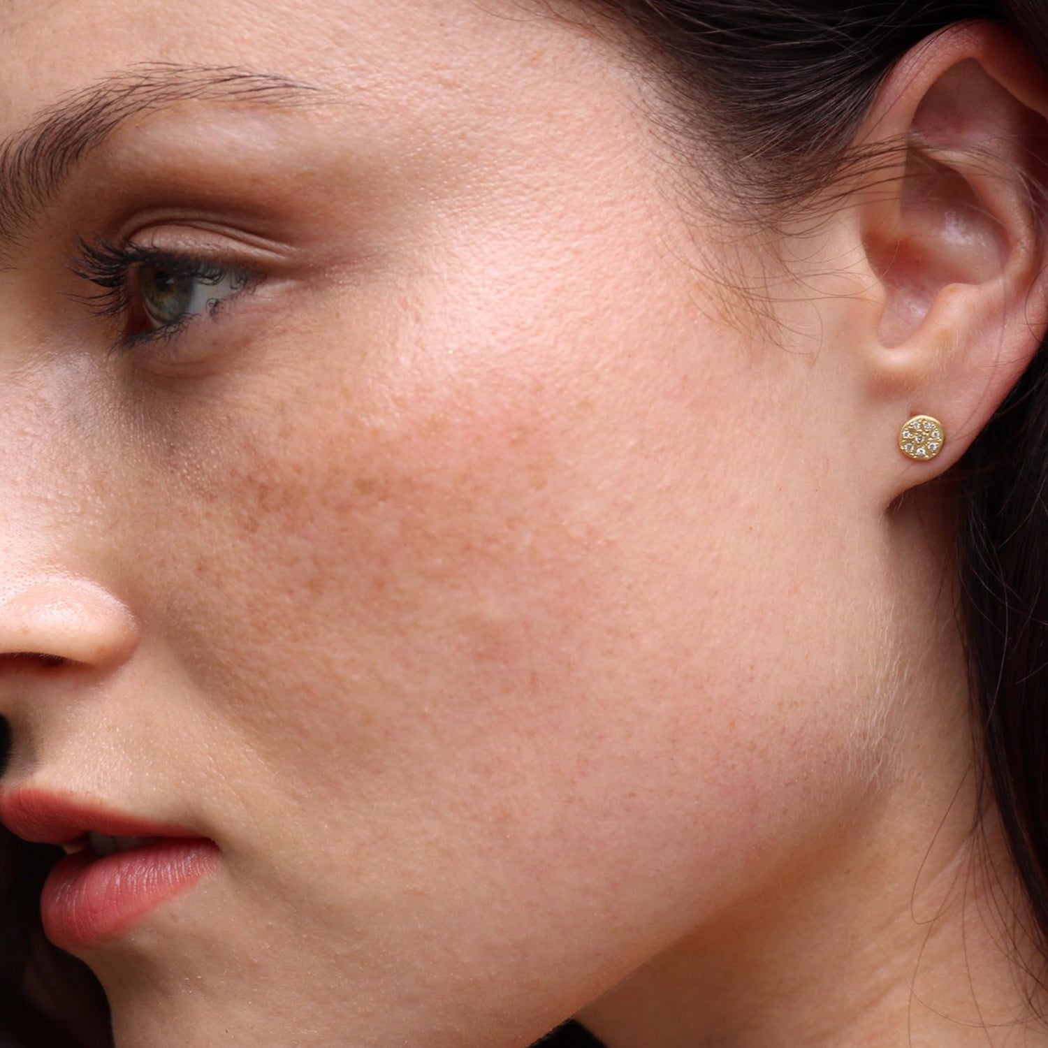 Brooke Gregson 18ct yellow gold 'Mini Mars' disc stud earrings set with 7 white diamonds on womens ear.