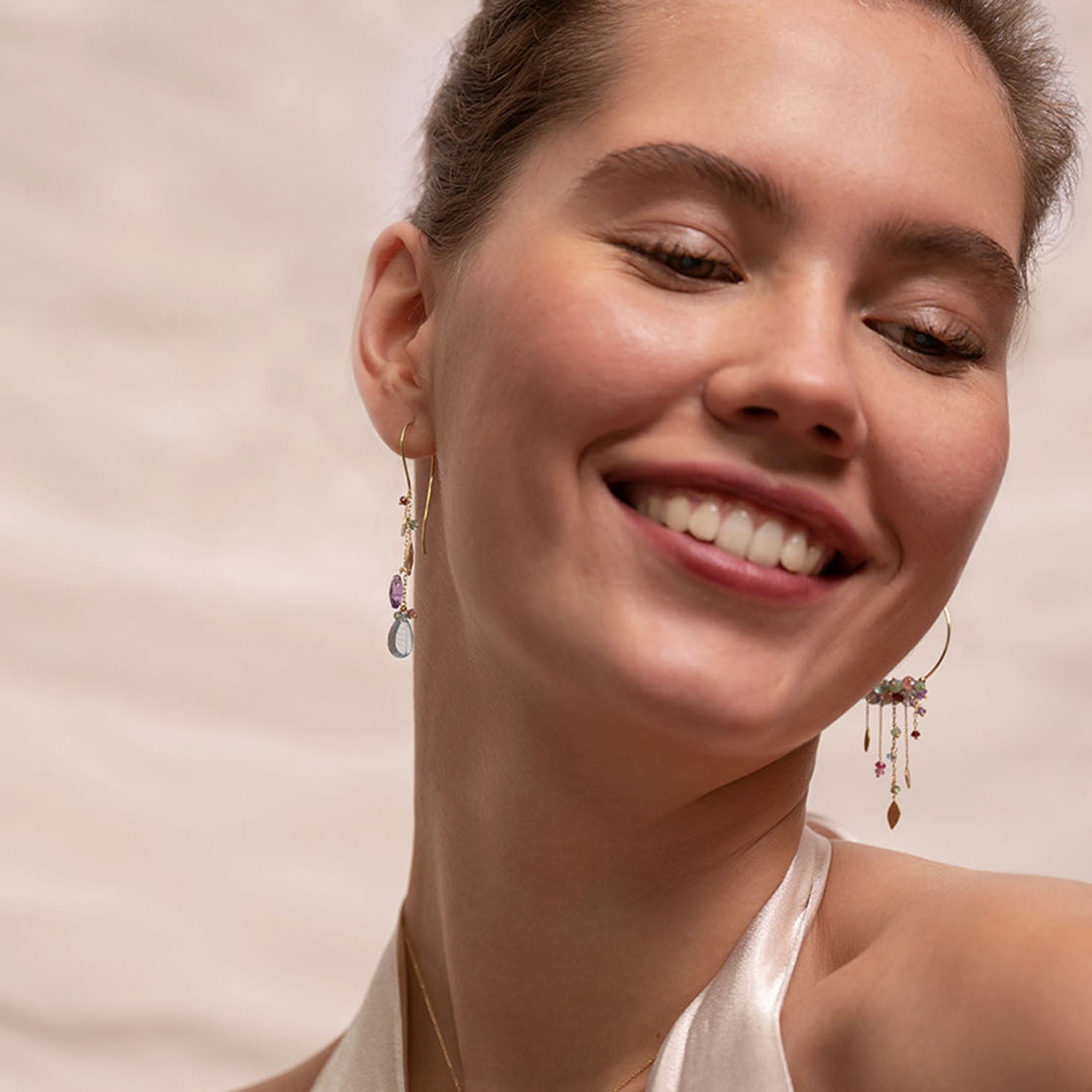 18ct Gold hook earrings with a cluster of stones and glistening gold leaves worn by model