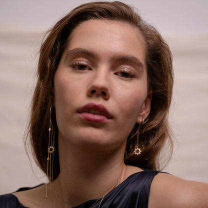 Sweet Pea 18ct yellow gold Reach For The Stars chain earring on model with large hoop in other ear. Star and chain hook earring on model with lathe hoop in other ear.