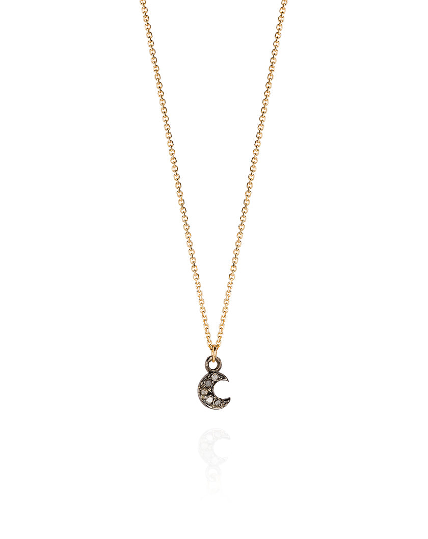 Tiny Laura Lee Diamond Set Moon Necklace. The teeny oxidised silver crescent moon is set with shining diamonds that catch the light as it hangs from a 9ct Gold chain.