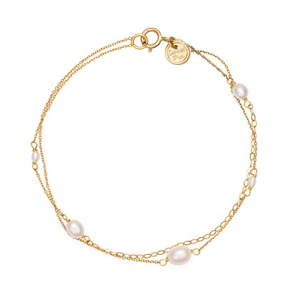 18ct Yellow Gold double strand bracelet with white oval shaped fresh water pearls and mixed fine chain detail. From our Snowdrop Pearl collection.
