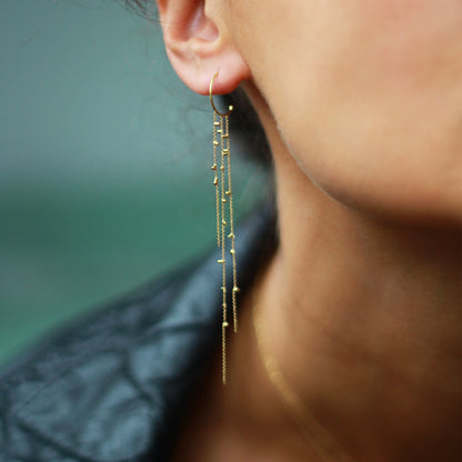 model wearing These fabulous hoop earrings are part of our Gold Dust Collection. The Hoops have three strands of 18ct yellow fine chain sprinkled with a shimmering of gold embellishments