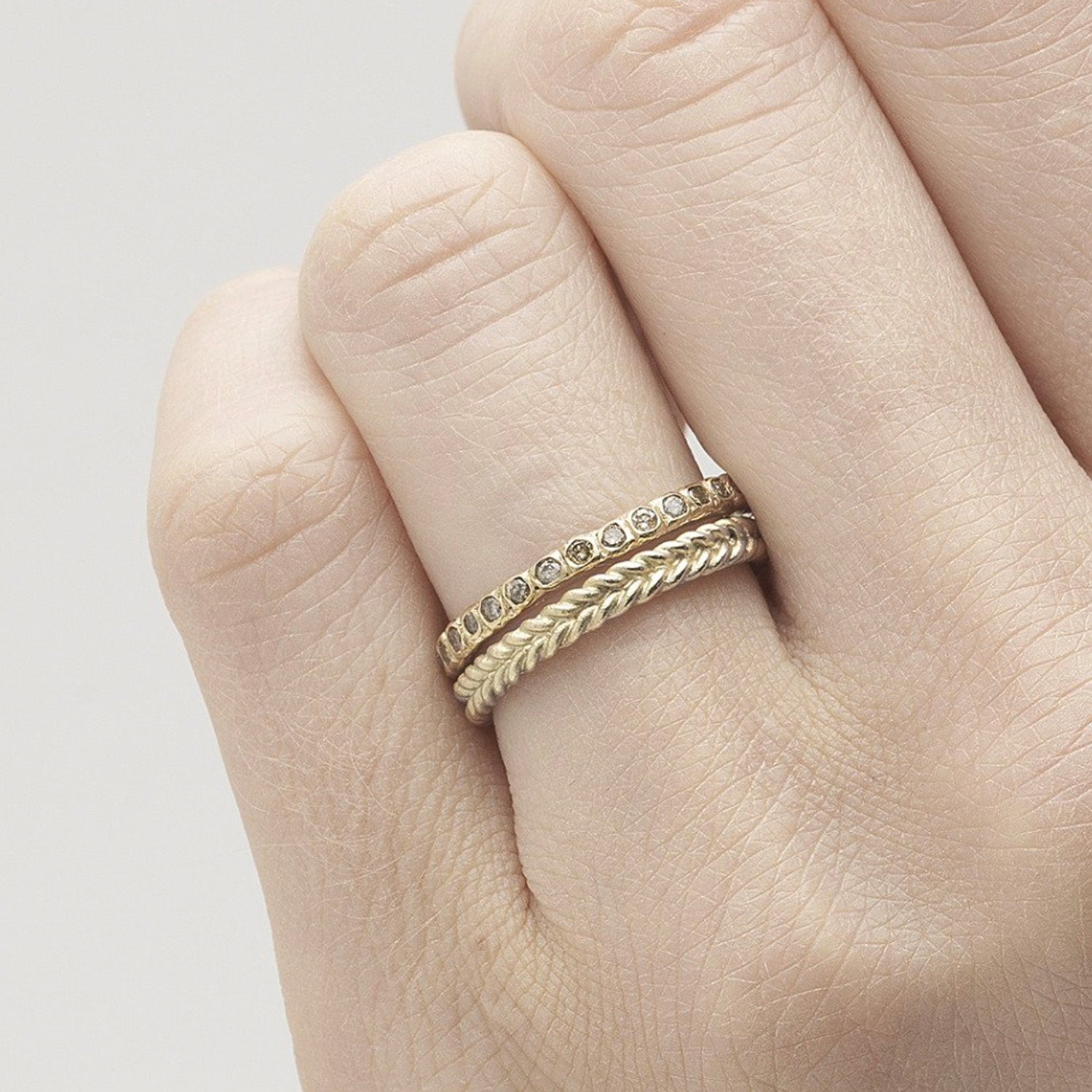 14ct yellow gold Ruth Tomlinson Champagne Diamond eternity band. Organic eternity band worn as a stack with a plaited band on a women finger. Organic diamond ring