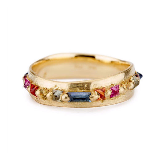 Polly Wales 18ct yellow gold Nina Pinched ring is a wide eternity band with rainbow, mixed cut sapphires. Organic rainbow ring.